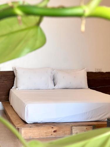 a bed with white sheets and pillows in a room at Beachfront Apartment with Kitchen and Outdoor Seating Area in Boracay
