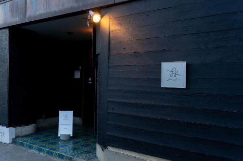 a black building with a sign on the side of it at Local Knot Backpackers in Nagano