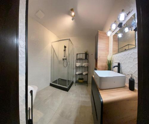 a bathroom with a tub and a shower and a sink at Polonia Apartments No-68 Near Piotrkowska in Łódź