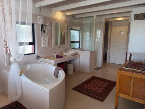 a large bathroom with a large tub and a sink and a tub at Absolute Beach Accommodation in Stompneusbaai