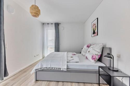 Una habitación blanca con una cama y una ventana en Zentral und ruhig Netflix Balkon Parkplatz, en Bruchsal