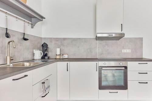 a kitchen with white cabinets and a sink at Zentral und ruhig Netflix Balkon Parkplatz in Bruchsal