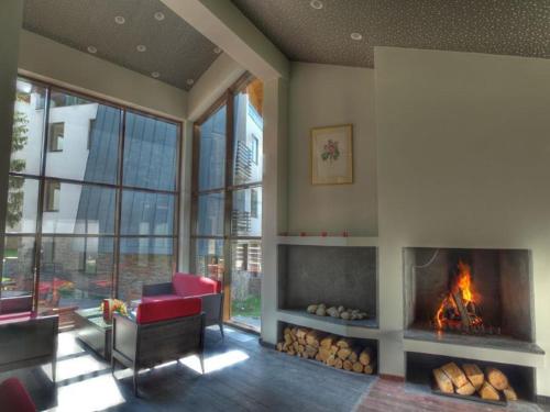 a living room with a fireplace and a red chair at Mountain Bliss 1-BR in Borovets
