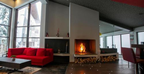 a living room with a red couch and a fire place at Mountain Bliss 1-BR in Borovets