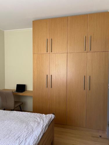 a bedroom with wooden cabinets and a desk with a bed at Mountain Bliss 1-BR in Borovets