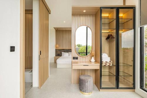 ein Bad mit einem Spiegel und ein Bett in einem Zimmer in der Unterkunft Private Villa Ayra 9E by OriVista 10mins to Melasti Beach in Uluwatu