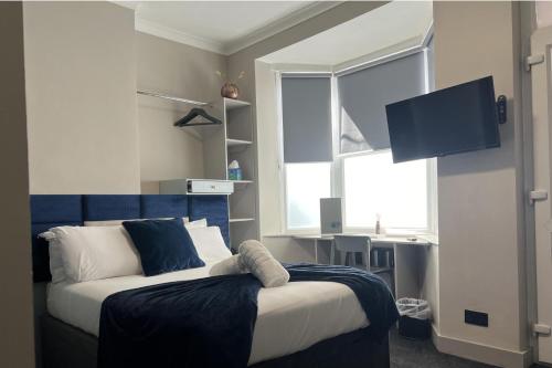 a bedroom with a bed with a blue headboard and a window at Snooker Stay Near Crucible - 4 En-Suite Beds- in Sheffield