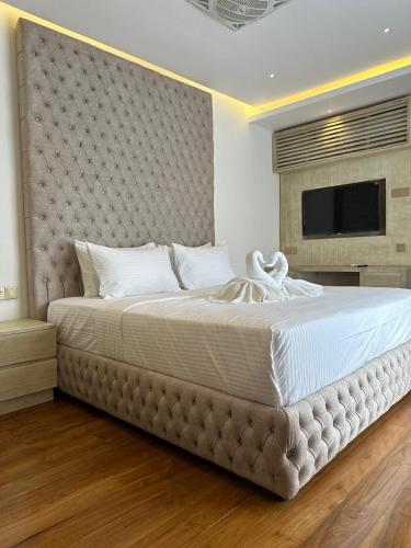 a bedroom with a large bed with a large headboard at Kings Landing Unawatuna in Unawatuna