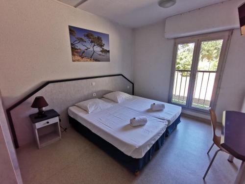 a bedroom with a bed with two towels on it at Les Voiles d'Azur in La Londe-les-Maures