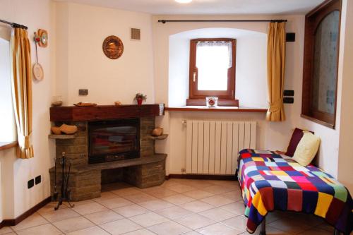 a living room with a fireplace and a chair at Casa D'antan Gressan in Aosta