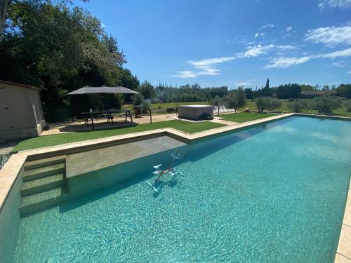 une piscine avec une table et un parasol dans l'établissement MASAPIER, à Avignon