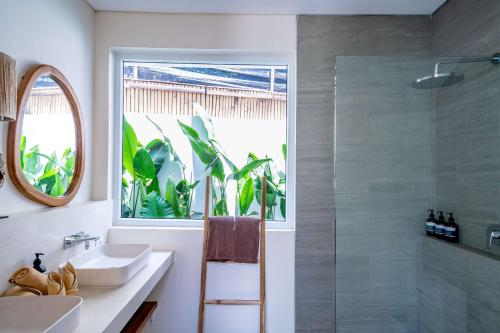 a bathroom with a shower and a sink and a window at Lyma Loft Pererenan in Canggu
