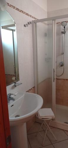 a white bathroom with a sink and a shower at Hotel IL Rifugio in Gonzaga