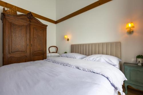 a bedroom with a large bed with white sheets at Villa Eliyas with Jacuzzi near the Pirin Golf Resort in Razlog