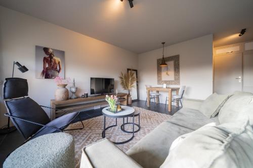 a living room with a couch and a table at Hello Noordwijk - Appartement Duindamseweg 14E in Noordwijk aan Zee
