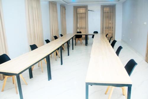 a long row of tables in a room with chairs at Caritas Inn, Ilasan in Lagos