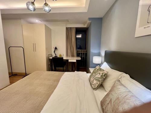 a bedroom with a large bed and a table at Shanghai Lerongju Boutique Apartment Metro Line 8 20meter in Shanghai