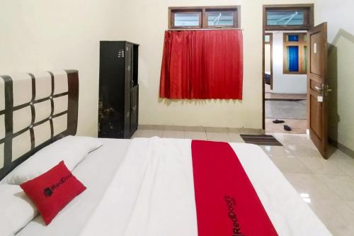 Postel nebo postele na pokoji v ubytování RedDoorz at Guesthouse Oemah Opa Metro Lampung