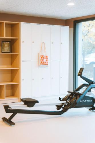 a gym with a treadmill next to a closet at Bikube Lyon in Lyon