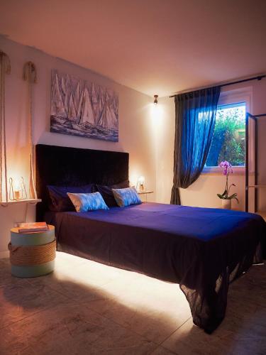 a bedroom with a large bed with blue sheets and a window at RedHouse Benaco in Torri del Benaco