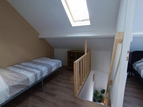 - une petite chambre avec un lit et une lucarne dans l'établissement Duplex Idéal Plage et Ville, à Dunkerque