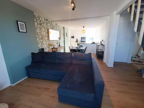 un salon avec un canapé bleu et une cuisine dans l'établissement Duplex Idéal Plage et Ville, à Dunkerque