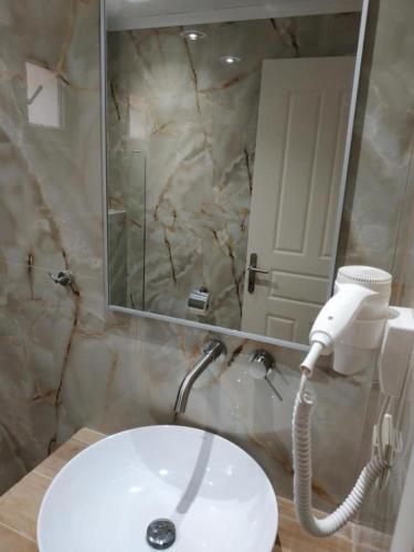 a bathroom with a white sink and a mirror at Rachoni Resort in Skala Rachoniou