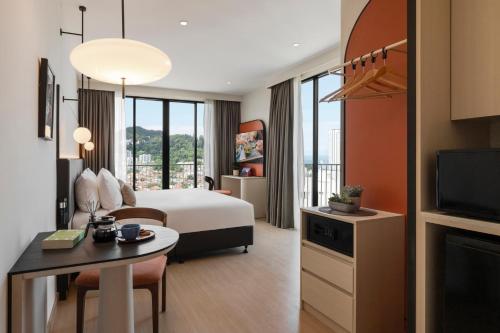 a hotel room with a bed and a television at Citadines Tanjung Tokong Penang in George Town