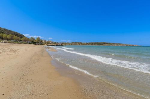 a sandy beach with waves coming in from the ocean at Martas Dream - Near Beach Apartments in Daratso