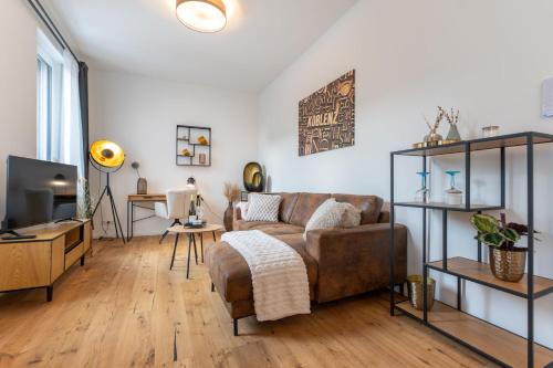 a living room with a couch and a table at Modernes Studio Augusta am Rhein, vollausgestattet, ruhig und verkehrsgünstig gelegen in Koblenz