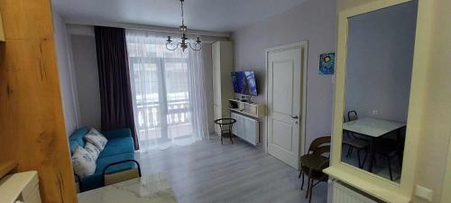 a living room with a blue couch and a table at Trialeti Sweet Home in Bakuriani