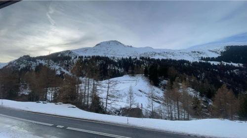 a view of a mountain with snow and a road at Les Nis in Bourg-Saint-Pierre