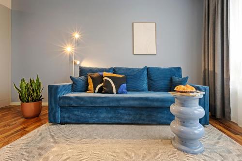 a blue couch with pillows on it in a living room at Max Aparthotel in Fürth in Fürth