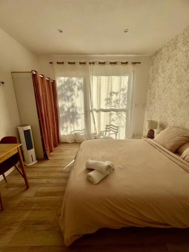 ein Schlafzimmer mit einem großen Bett und einem Handtuch darauf in der Unterkunft Studio paisible dans un quartier calme in Marguerittes