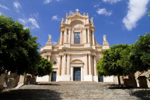 a large building with a clock tower and stairs at SI-Moutique Le Case degli Avi barocche, con terrazza panoramica in Modica