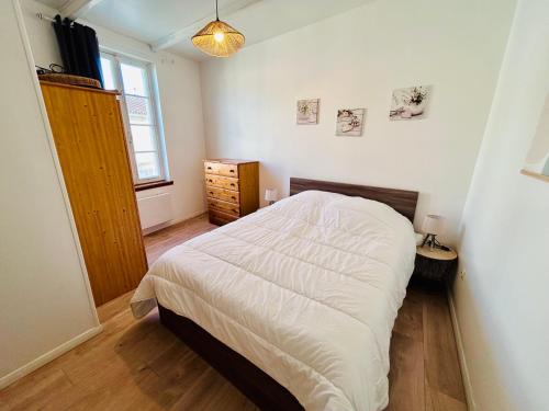 a bedroom with a white bed and a window at L'Envol - Spacieuse maison avec piscine privative in Champagne