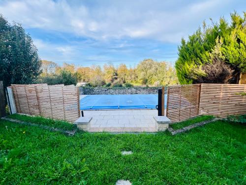 a swimming pool in a yard with a wooden fence at L'Envol - Spacieuse maison avec piscine privative in Champagne