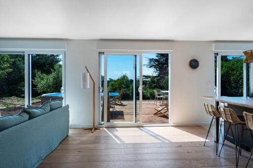 a living room with sliding glass doors and a table at La Villa Des Caps - Entre centre-ville et port in Erquy