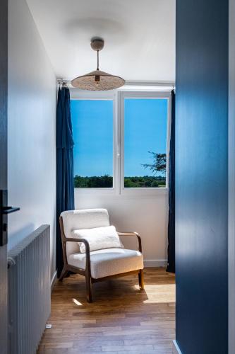 a chair in a room with a window at La Villa Des Caps - Entre centre-ville et port in Erquy