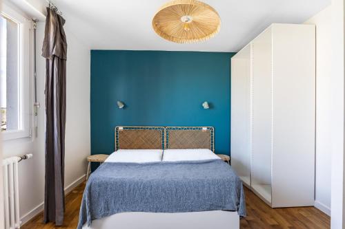 a bedroom with a blue wall and a bed at La Villa Des Caps - Entre centre-ville et port in Erquy