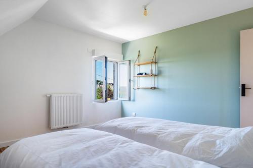 a bedroom with a white bed and blue walls at La Villa Des Caps - Entre centre-ville et port in Erquy