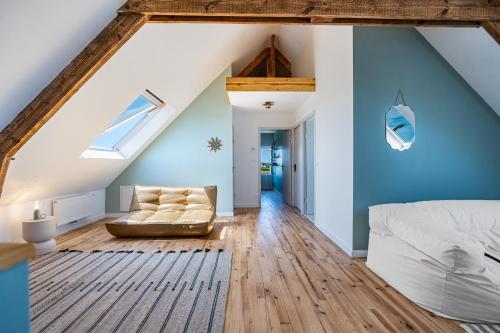 a attic bedroom with a bed and a couch at La Villa Des Caps - Entre centre-ville et port in Erquy
