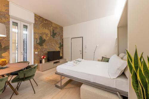 a bedroom with a large bed and a dining table at Argonne 51 Spazio Argonne studio apartment in Milan