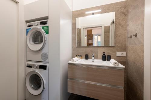 a bathroom with a sink and a washer and dryer at Argonne 51 Spazio Argonne studio apartment in Milan
