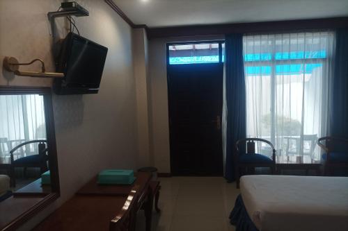 a room with a bed and a tv and a window at Hotel Efita in Kamparganya