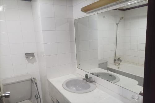 a white bathroom with a sink and a mirror at Hotel Efita in Kamparganya