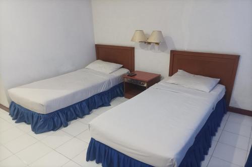 two beds in a hotel room with a table at Hotel Efita in Kamparganya