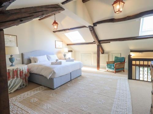 Un dormitorio con una cama grande y una silla. en Green Yew, en Windermere