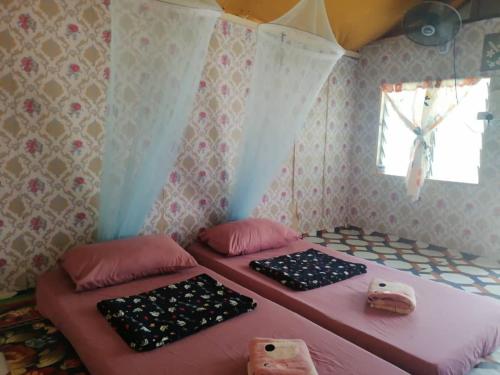 Giường trong phòng chung tại Sukau Sandipau Stay