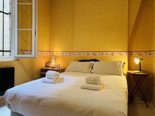 une chambre avec un grand lit blanc avec des serviettes dessus dans l'établissement Panorama Fondaudege, à Bordeaux